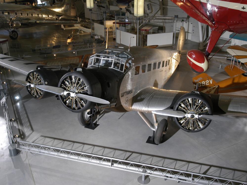 Silver-colored and black monoplane with three engines displayed in the museum.