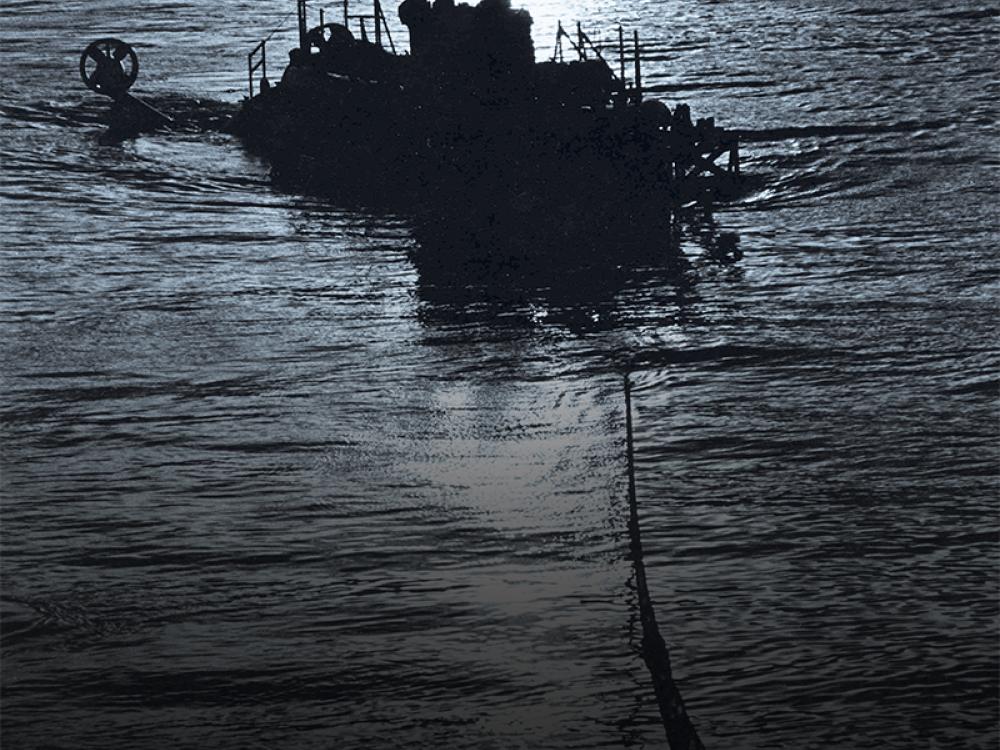 A silhouette of a boat being towed during nighttime hours