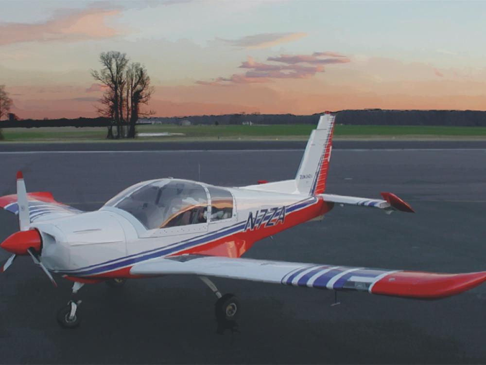 Red and white monoplane with blue-colored accents and single engine. The registration number "N7ZA" is painted in blue near the rear of the fuselage.