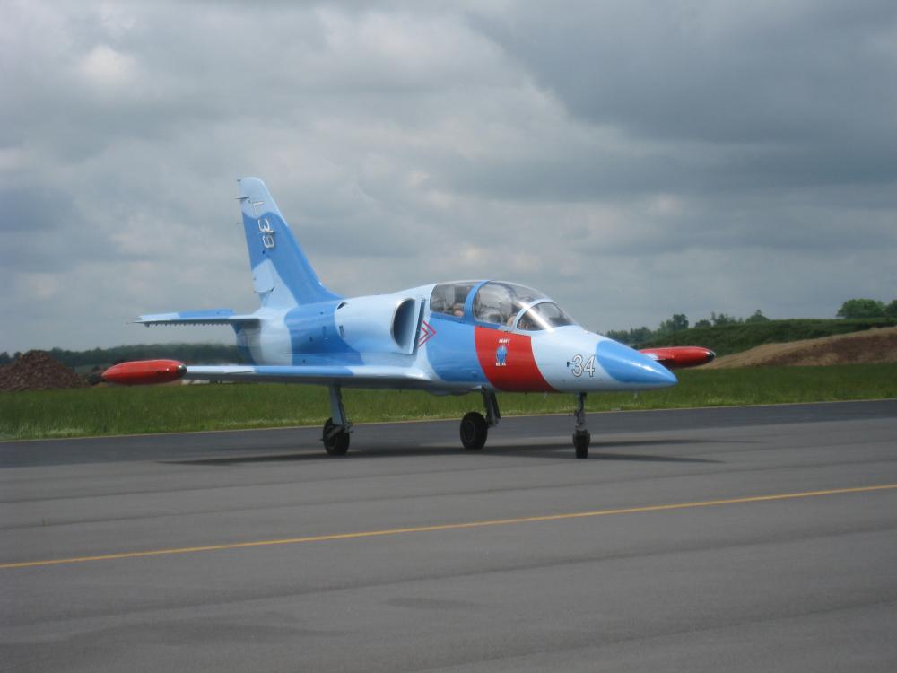 Side view of a blue and white monoplane with red accents. The single engine is not visible from this view.