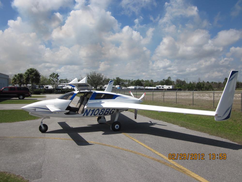 Side view of white aircraft with long back wings and a rear single engine. The registration number "N108BG" is painted in blue under the wing.