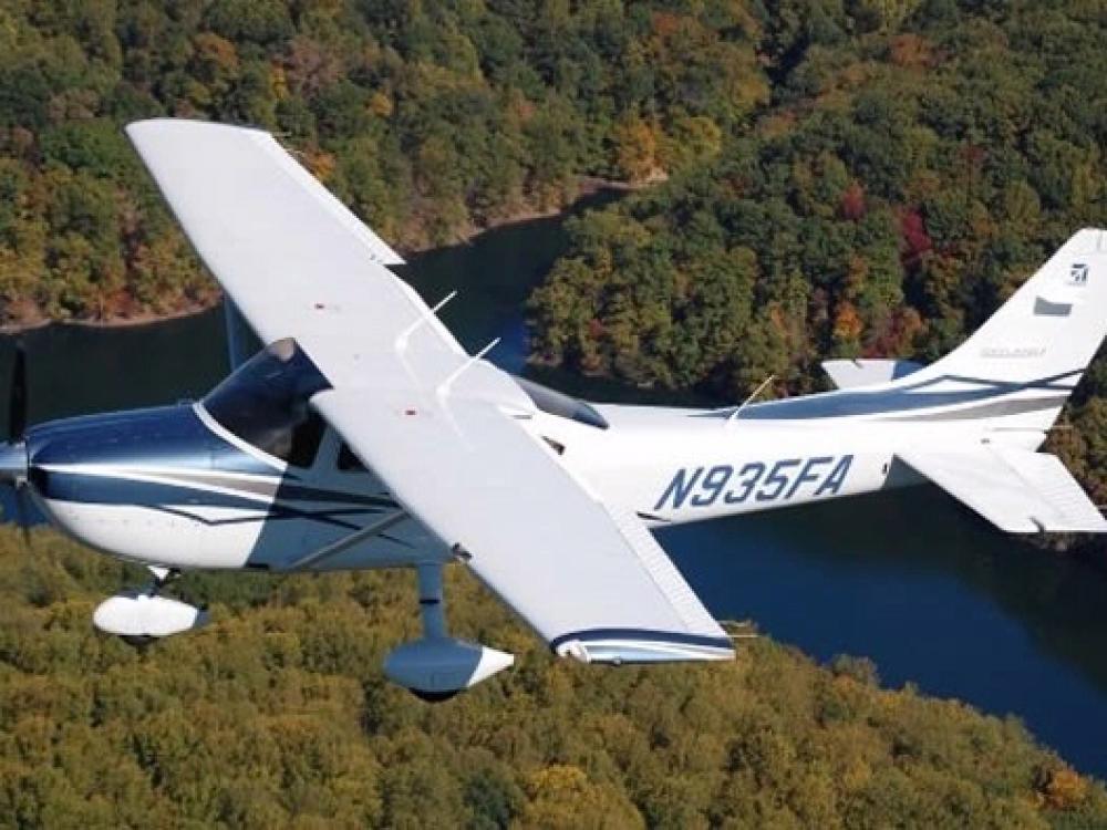 Top and side view of white monoplane with single engine and fixed landing gear. Registration number "N935FA" is painted in a dark blue color near the rear of the fuselage.