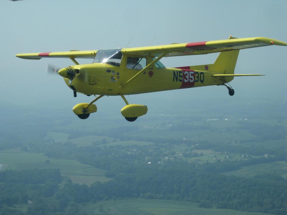 Side view of lime green monoplane in flight with one engine and fixed landing gear. The registration number "N5353Q" is painted near the rear of the fuselage.