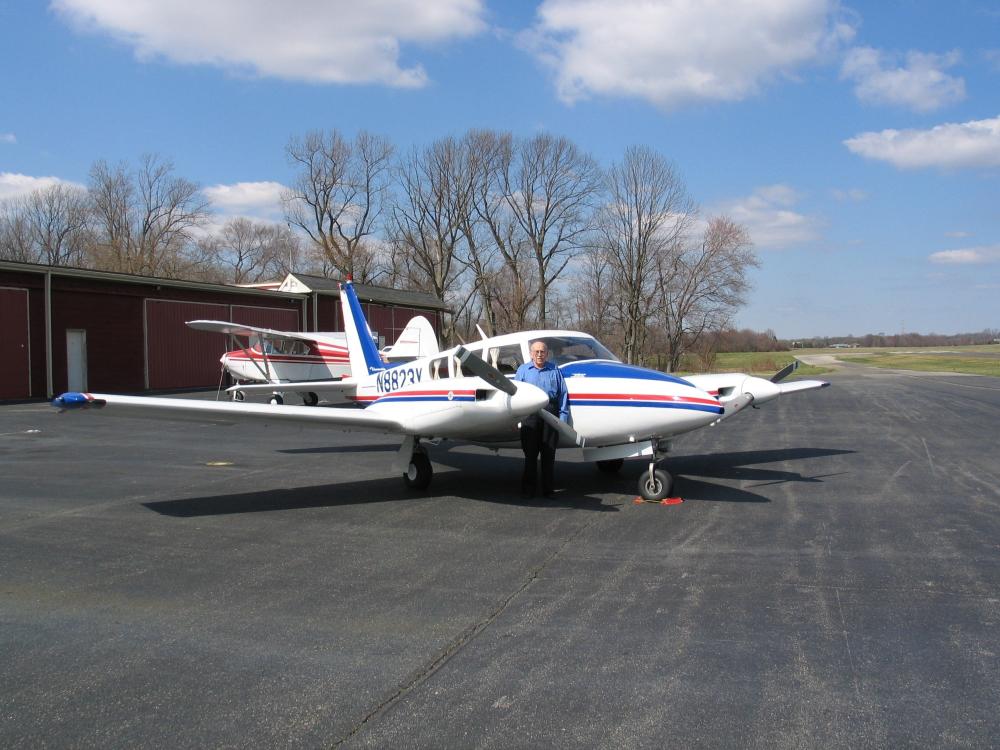 Diagonal front and side view of white aircraft with blue and red accent colors and twin engines.