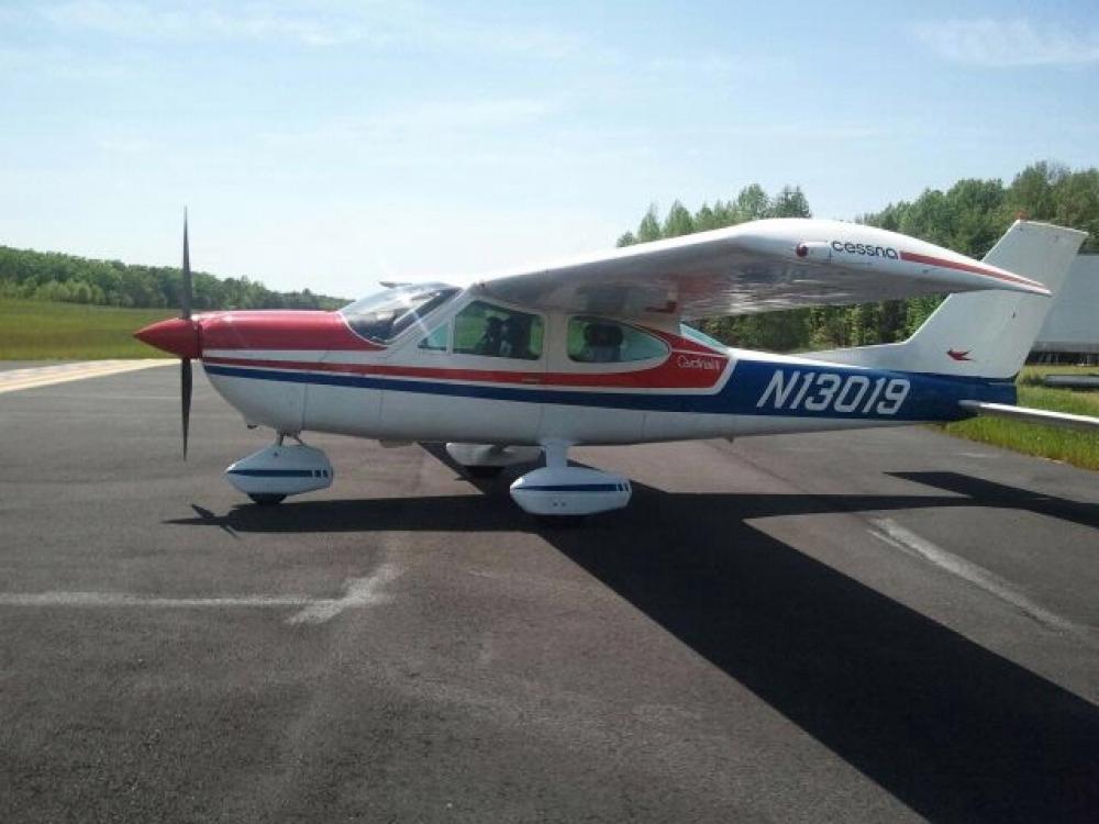 Side view of white, red, and blue monoplane with one engine and fixed landing gear. The registration number "N13019" is painted in white near rear of fuselage.