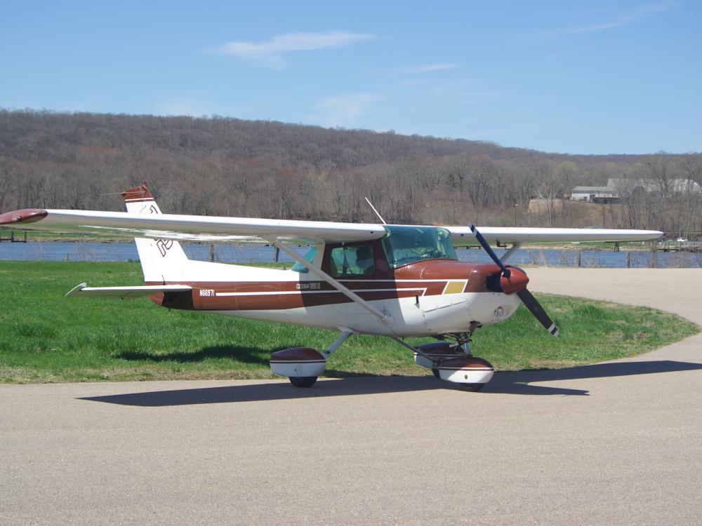 Side view of white and brown monoplane with single engine and fixed landing gear.