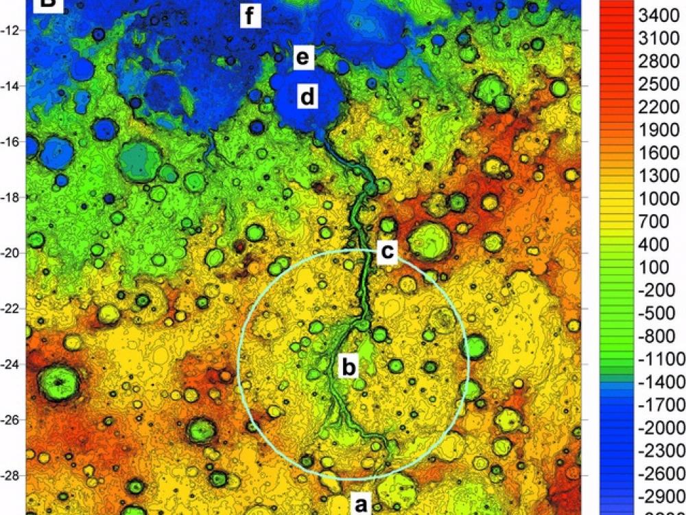 Colored topographical map of an area of Mars featuring a large outflow channel of scoured land.