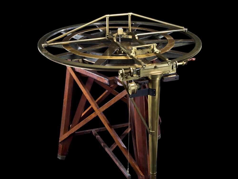 A navigation tool with a circular top and a three-legged base.