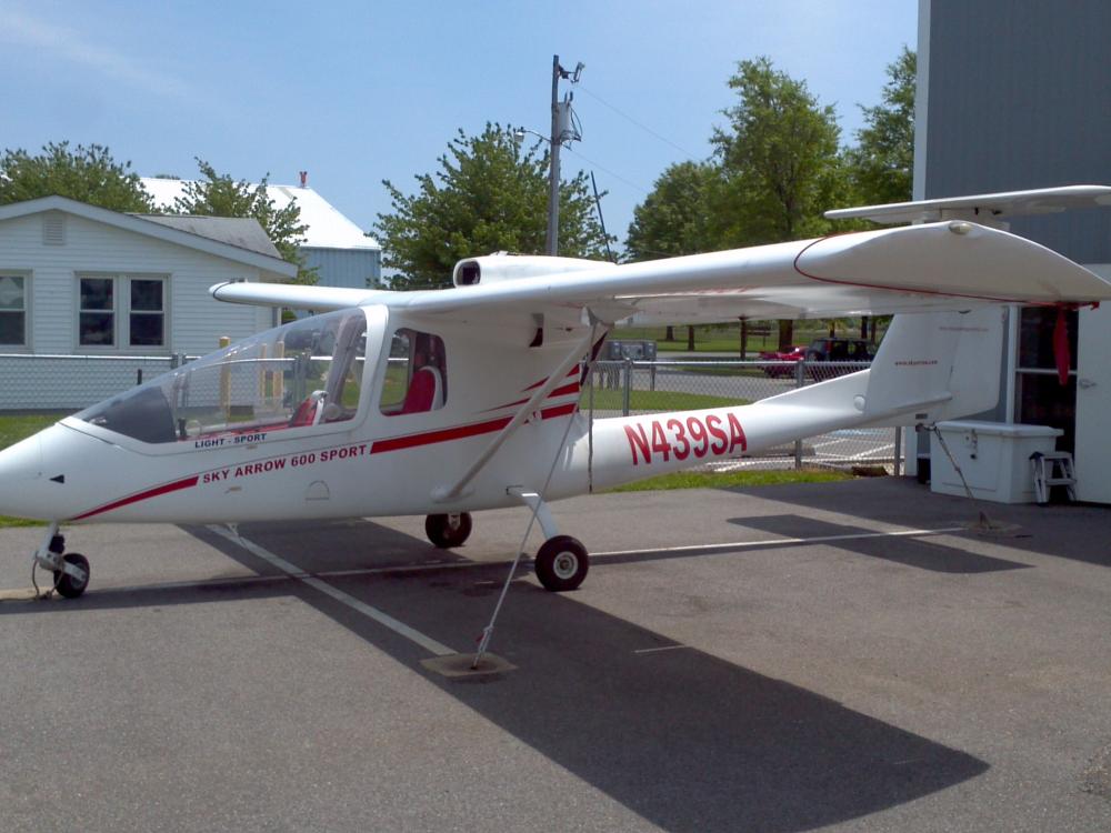 Side view of white monoplane with red accents and a single engine. The registration number N439S4 is painted in red between the fuselage and the vertical stabilizer.