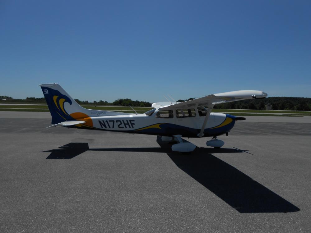 Side view of white and black monoplane with single engine. Registration number "N172HF" is painted in black near the rear of the fuselage.