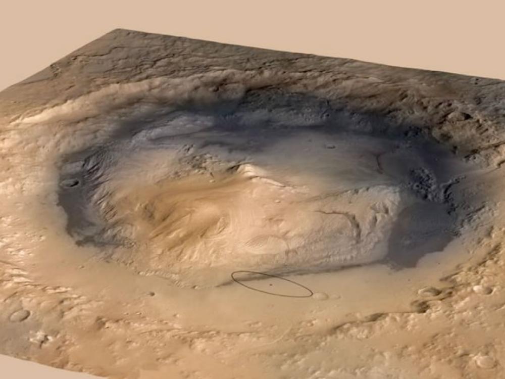 A three-dimensional view of a crater on Mars and the nearby surface. A small ellipse represents a Mars Rover which travelled up a mountain inside of the crater.