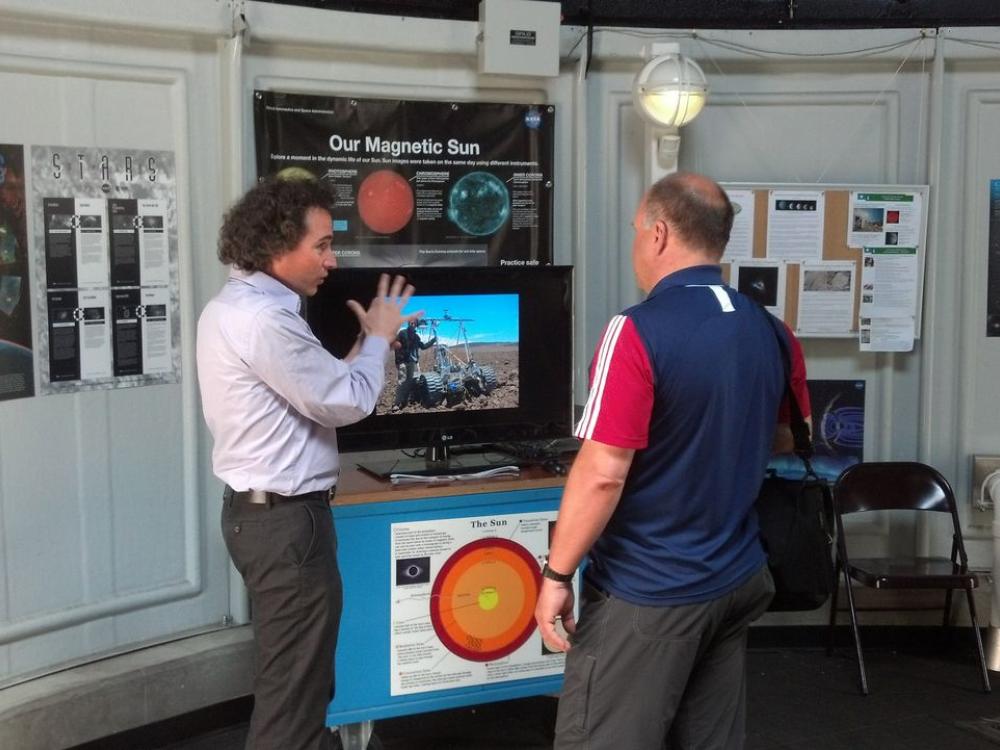 A visitor chats with a museum expert on astronomy inside the museum's observatory.