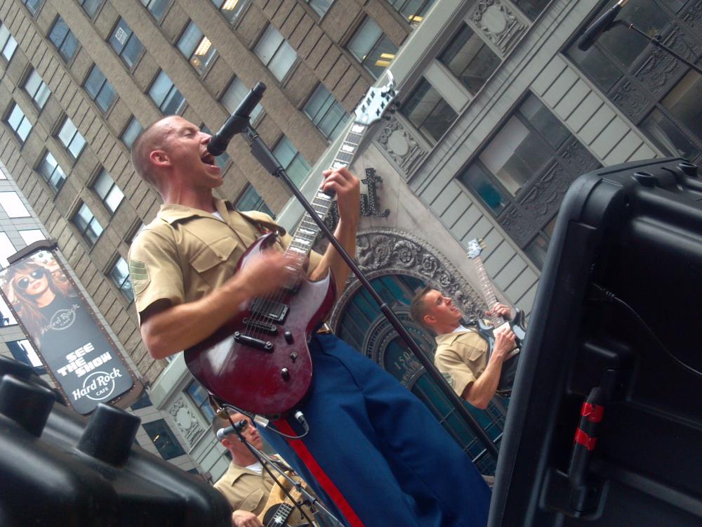 A group of Marine Corps musicians perform as part of a rock band.