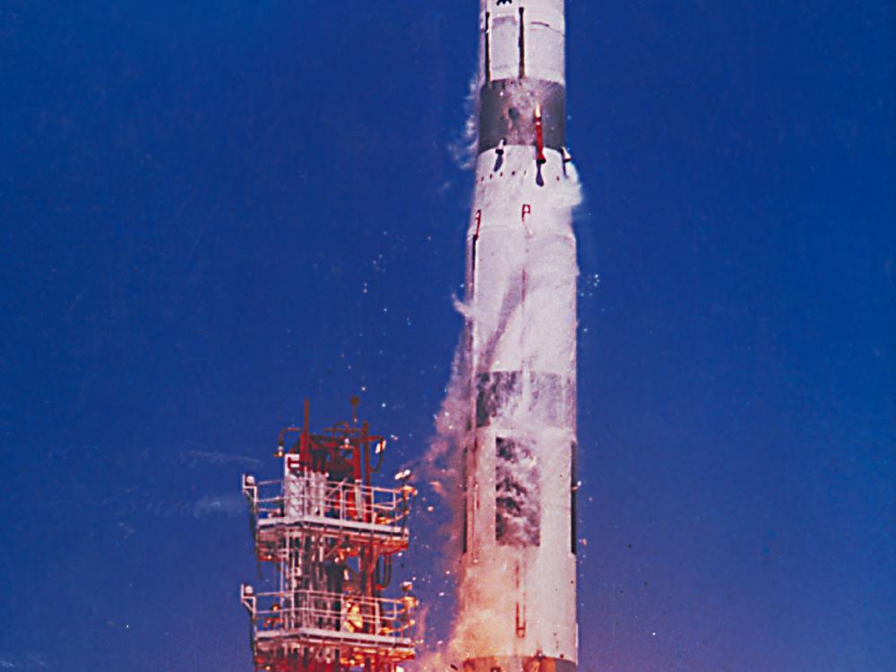 A white and gray missile in the middle of a launch sequence.