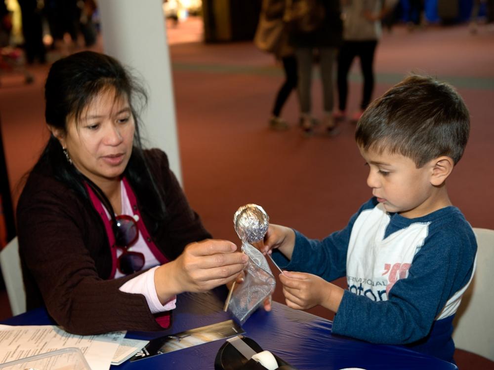 Two museum visitors participate in a craft activity at the museum.