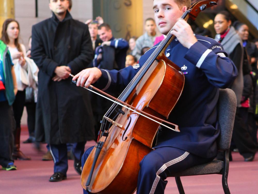 A cellist in U.S. Air Force uniform plays during a surprise performance at the Museum.