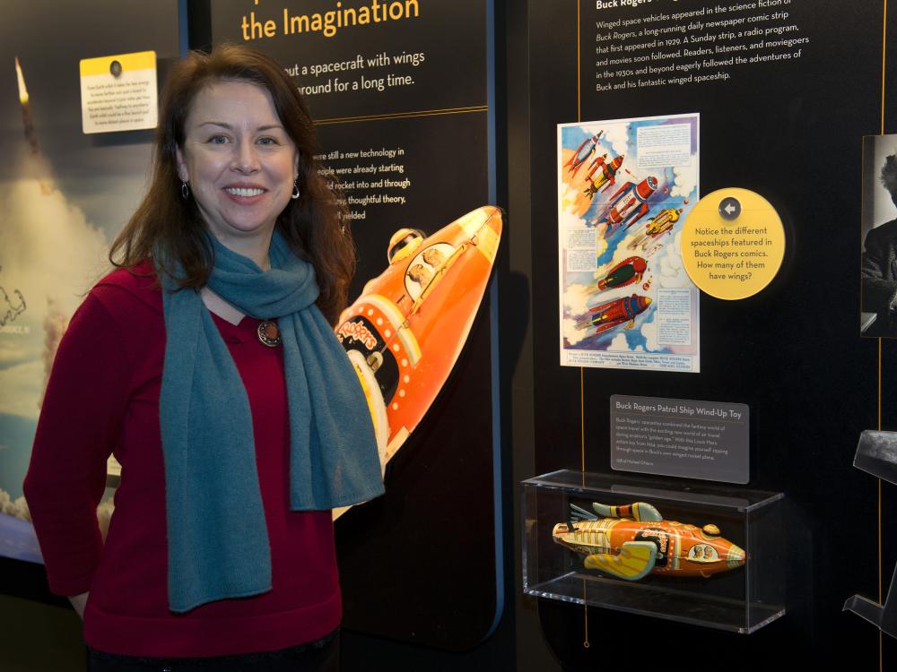 Margaret Weitekamp, the Museum's Curator of Space History, stands in front of an exhibit about space.