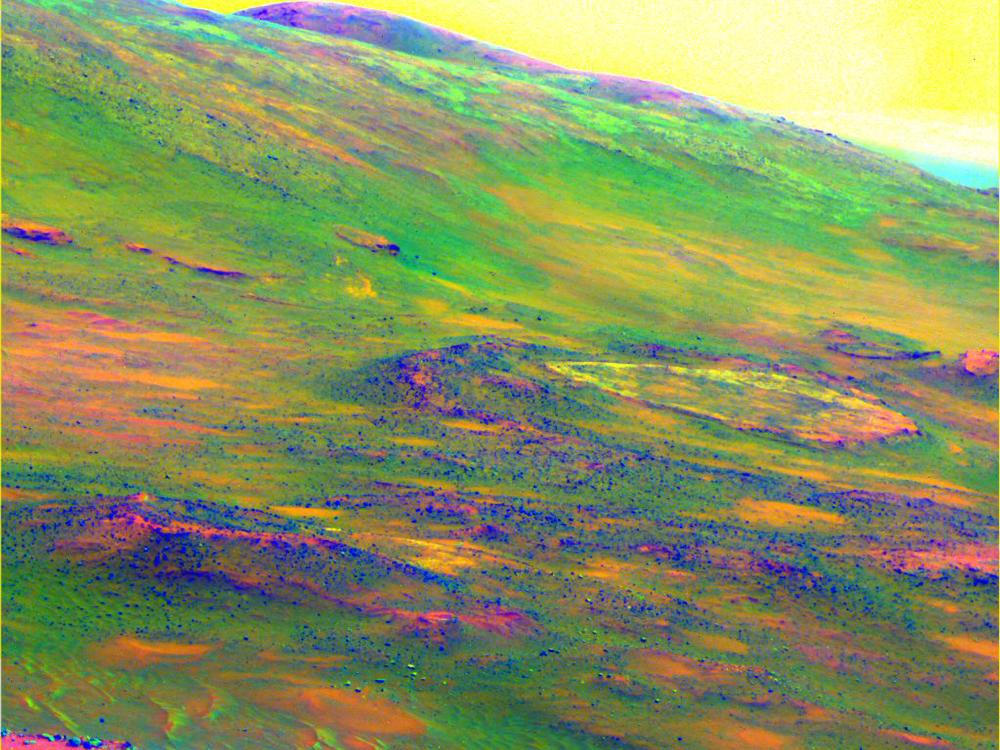 A colored view of rock weathering on a specific area of Mars. A dust devil in the upper right is depicted as a darker yellow color to the rest of the sky.