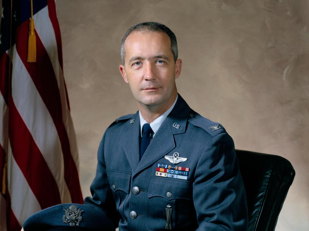 Gen. James A. McDivitt, a white male, sits for a professional portrait in his U.S. Air Force uniform.