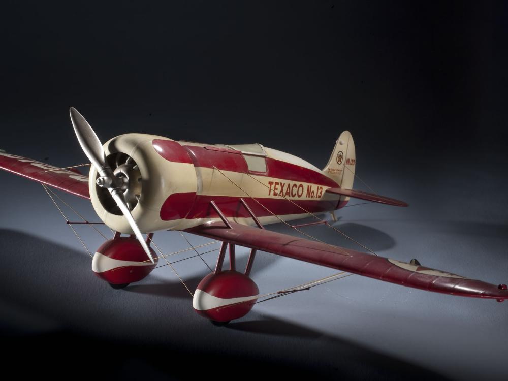 White and red monoplane model with one engine. "Texaco No. 12" is painted in red near the rear of the fuselage.