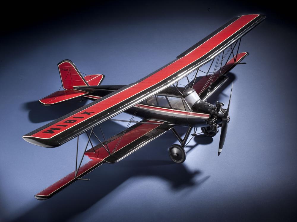 Top and side view of red and black biplane model with one engine. 