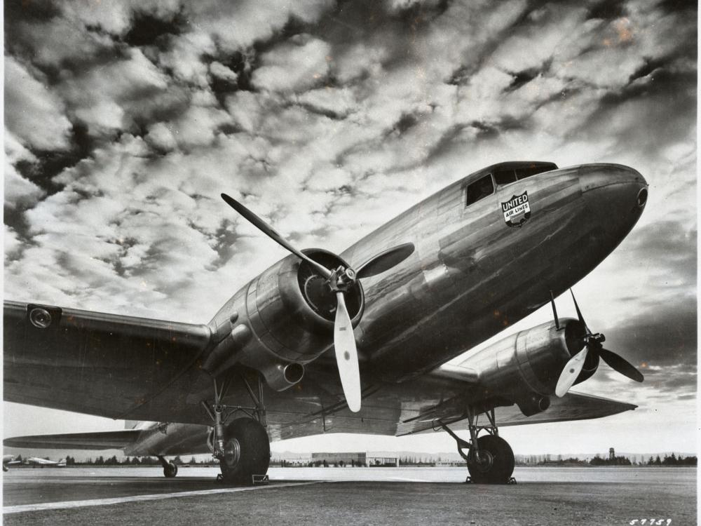 Front view of a commercial aircraft with twin, three-blade propellor engines.