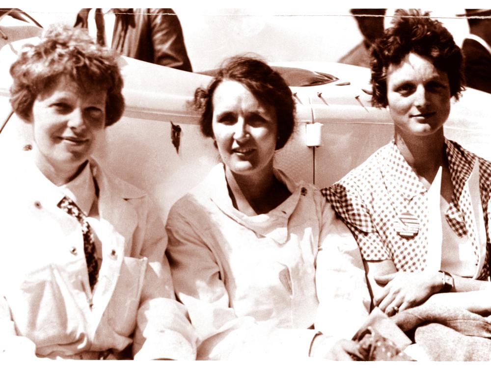 Amelia Earhart, Ruth Nichols, and Louise Thaden, all of whom are white women, sit together.