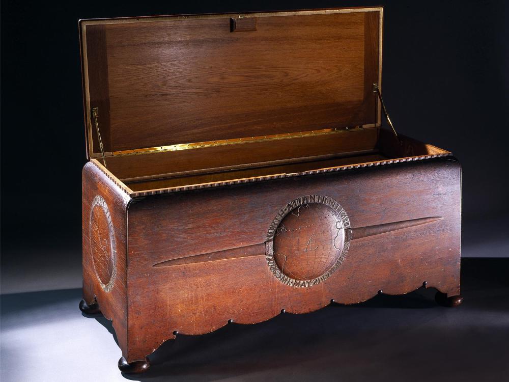 Opened wooden chest commissioned to hold the trophies, plaques, and memorabilia belonging to Amelia Earhart. The chest features motifs highlighting three of Earhart's milestone flights.