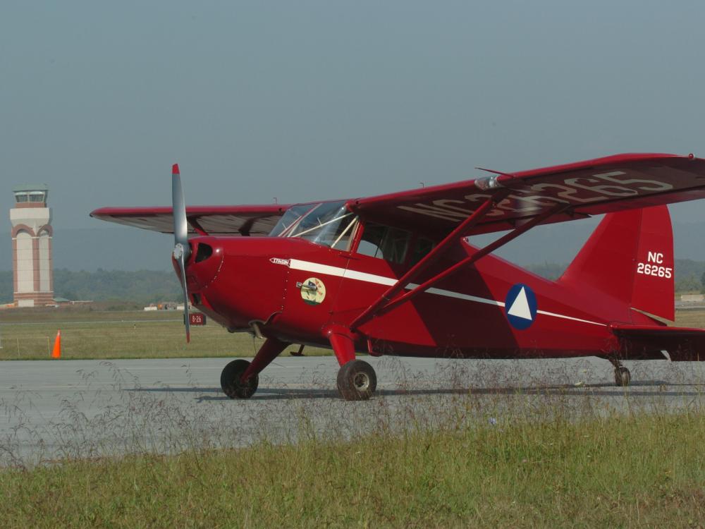 Side view of red monoplane with one engine.