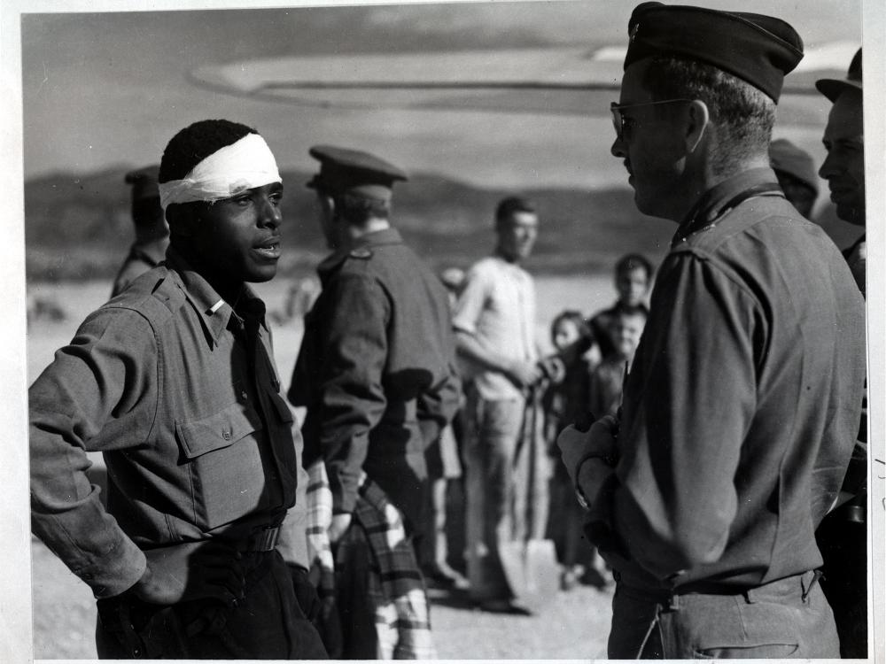 Lt. Andrew D. Mitchell, an African-American male pilot on the left, speaks to another officer following an escape attempt from German territory.