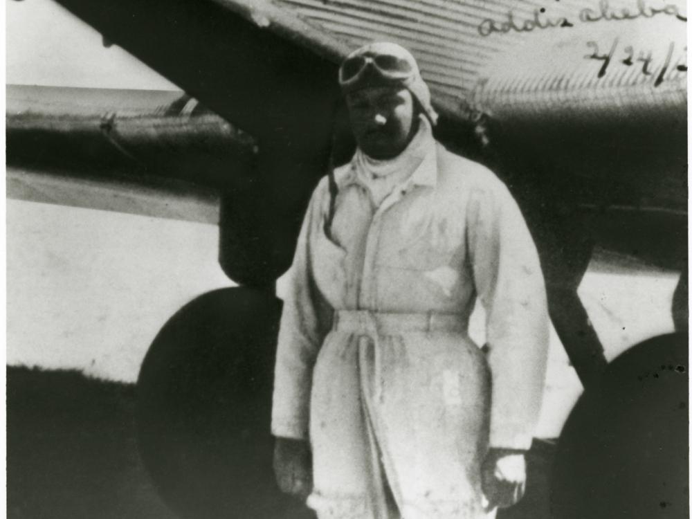 John C. Robinson, an African-American male pilot, poses informally in front of an aircraft.