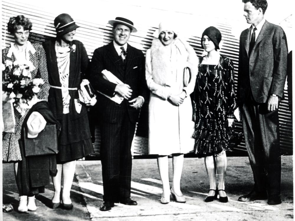 Amelia Earhart, a white woman, stands with other white people including Charles and Anne Lindbergh, featured on the right.