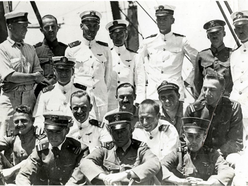 An informal photo of the original U.S.S. Langley pilots, who are in uniform. In the back row, Alfred Melville Pride stands second from the right and Godfrey Chevalier stands in the center.