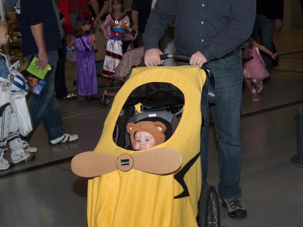 An infant is dressed up in a Piper Cub-inspired Halloween costume during the Museum's annual Halloween event.