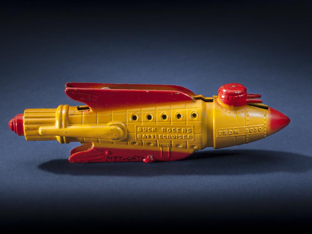 Side view of yellow rocket with red fins and nose.