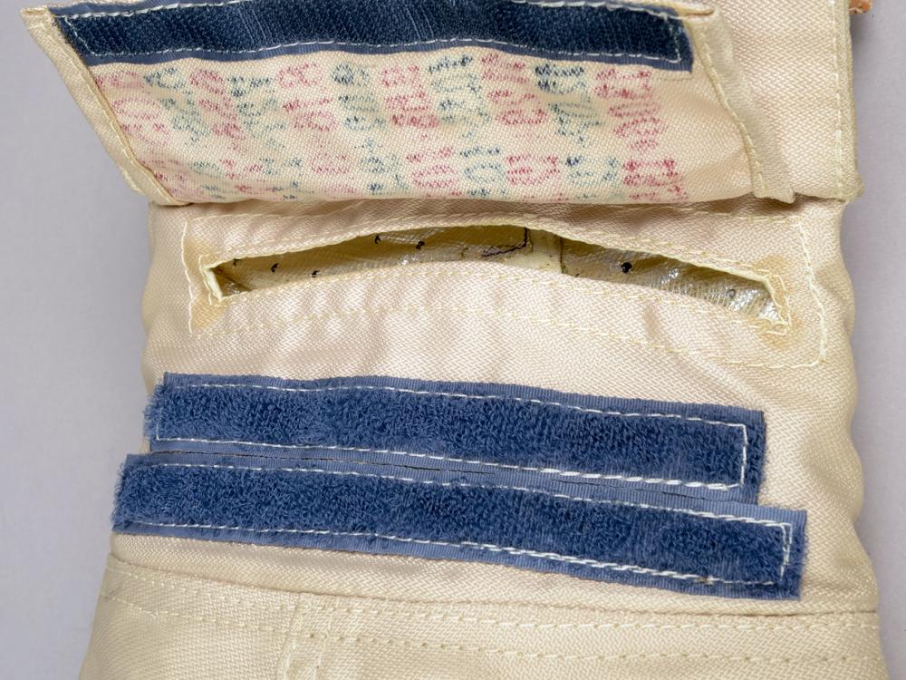 Close-up view of glove on cosmonaut suit, featuring a flap that would include a written checklist for spacewalks.