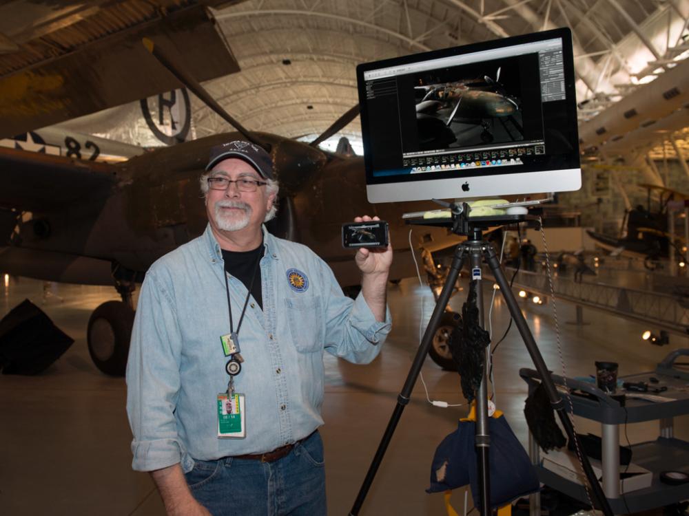 A Museum staff member uses a display monitor to provide photography advice at an open house event for the Museum.