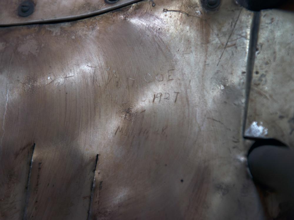 Signatures from engineers and guards etched onto a portion of a silver monoplane. 