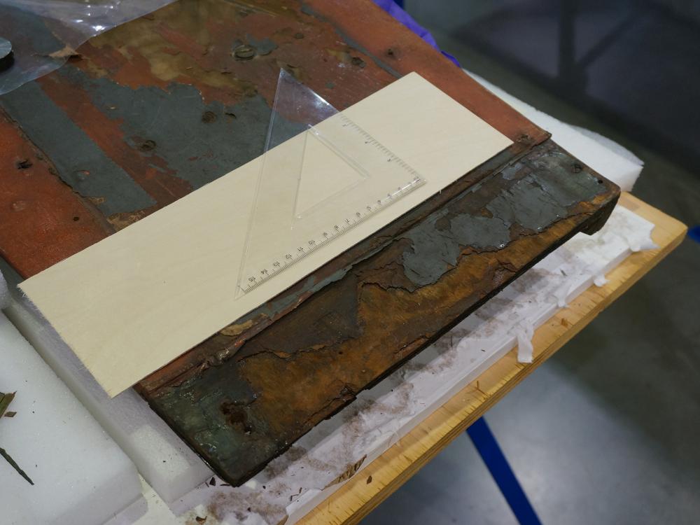 A deteriorated section of a World War II era aircraft prior to receiving conservation treatments. Discoloration and loss of materials can be seen.