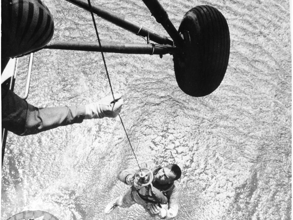 A Navy helicopter hoists Alan Shepard from the ocean after his flight.