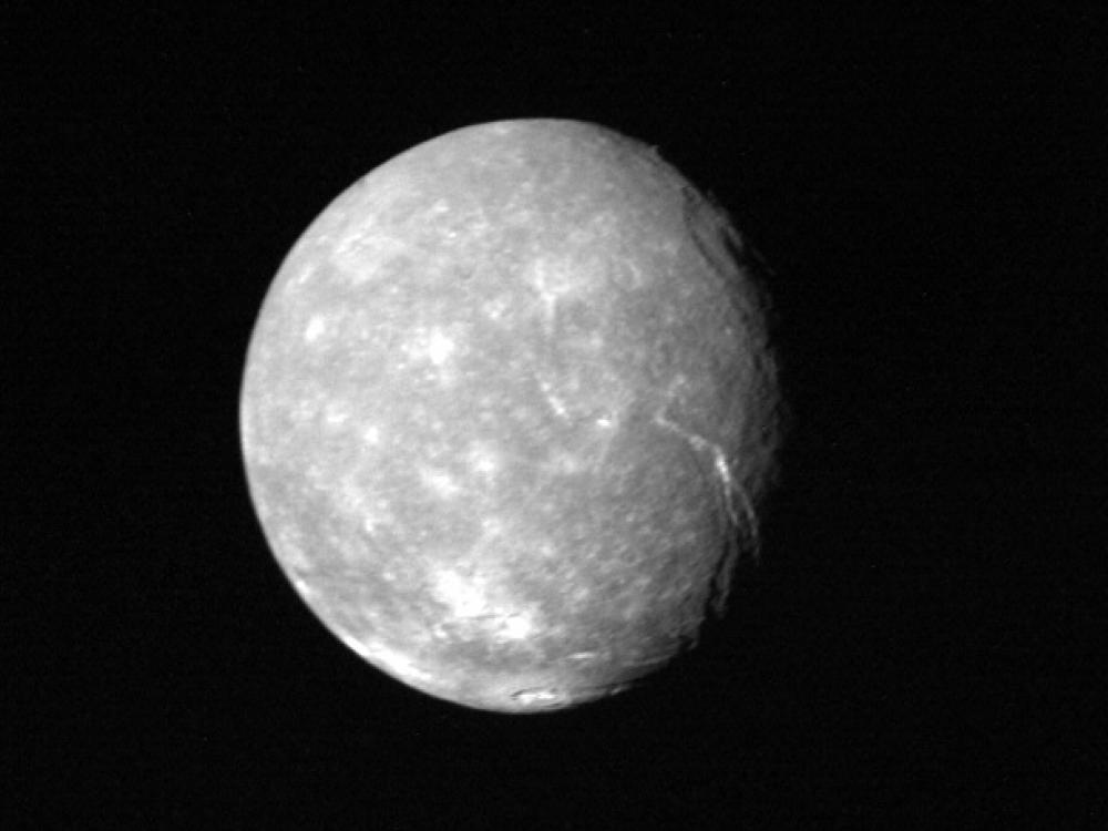 A full disk view of Titania, a moon of Uranus. Multiple large fault canyons can be seen on the right side of the disk.