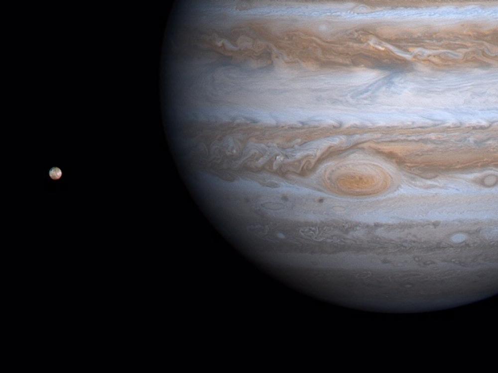 A partial view of Jupiter in comparison to its closest large moon, Io.