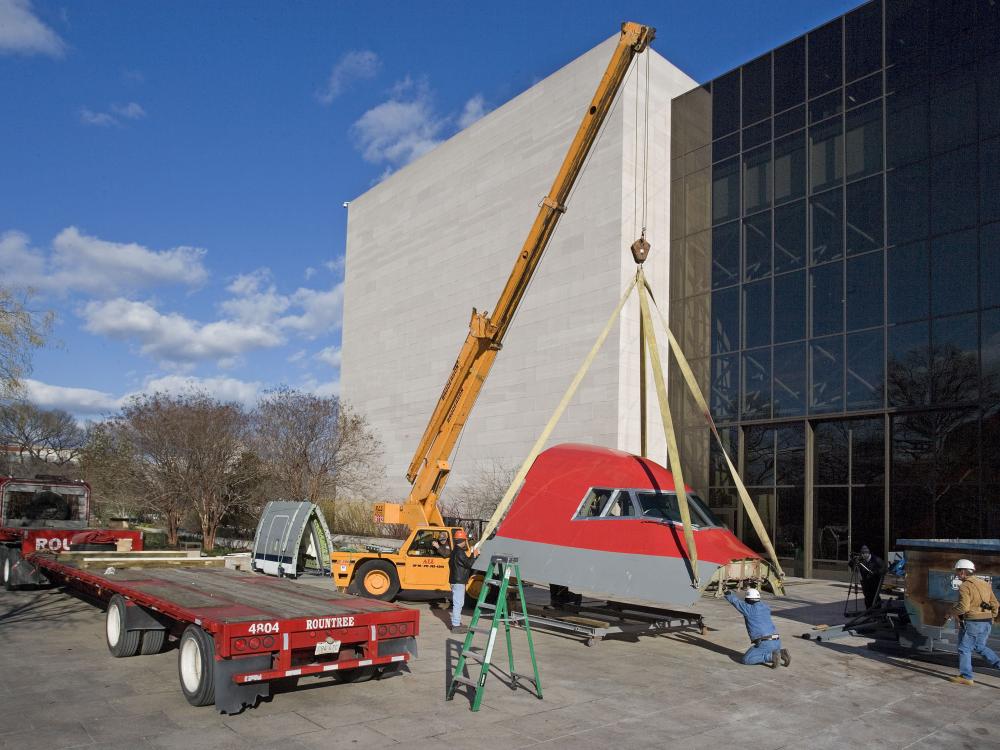 Museum employees begin to lift the Boeing 147 outside of the flagship museum building prior to installation inside the building.