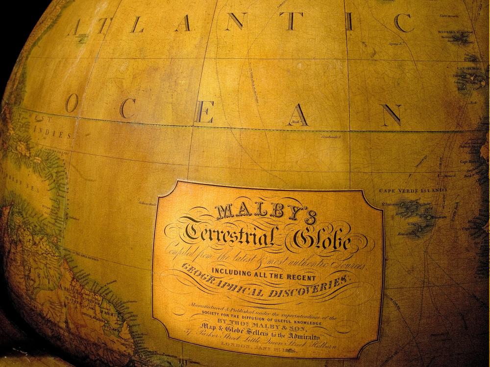 View of nineteenth-century wooden globe focusing on branding below markings indicating North Atlantic Ocean