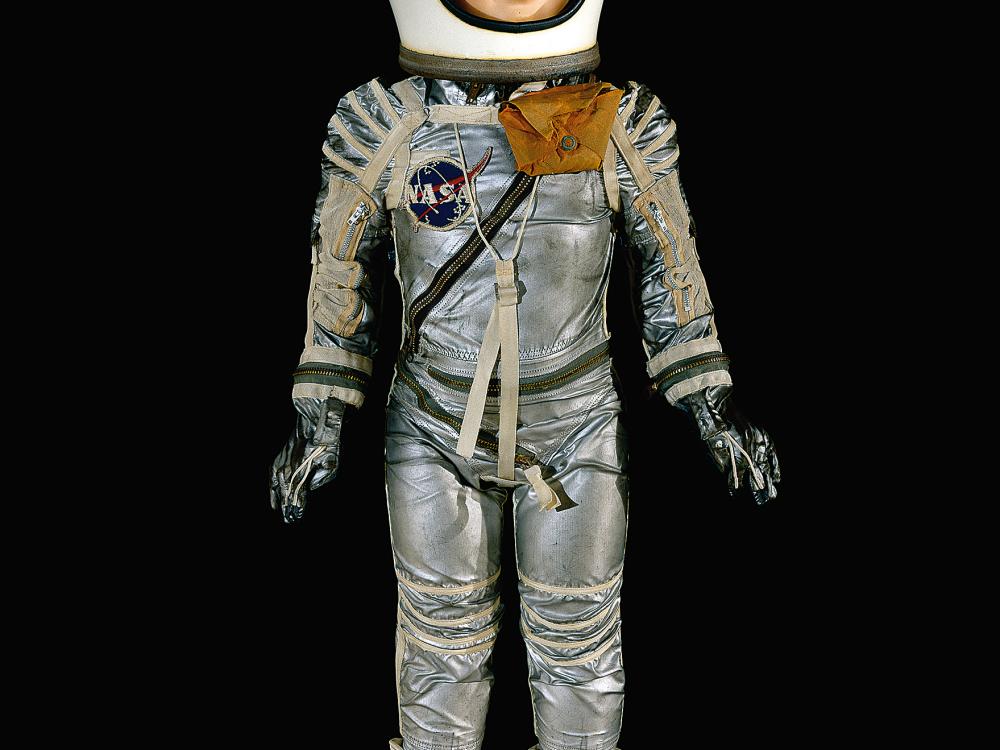 Child-size doll in silver spacesuit with white helmet and white rubber boots