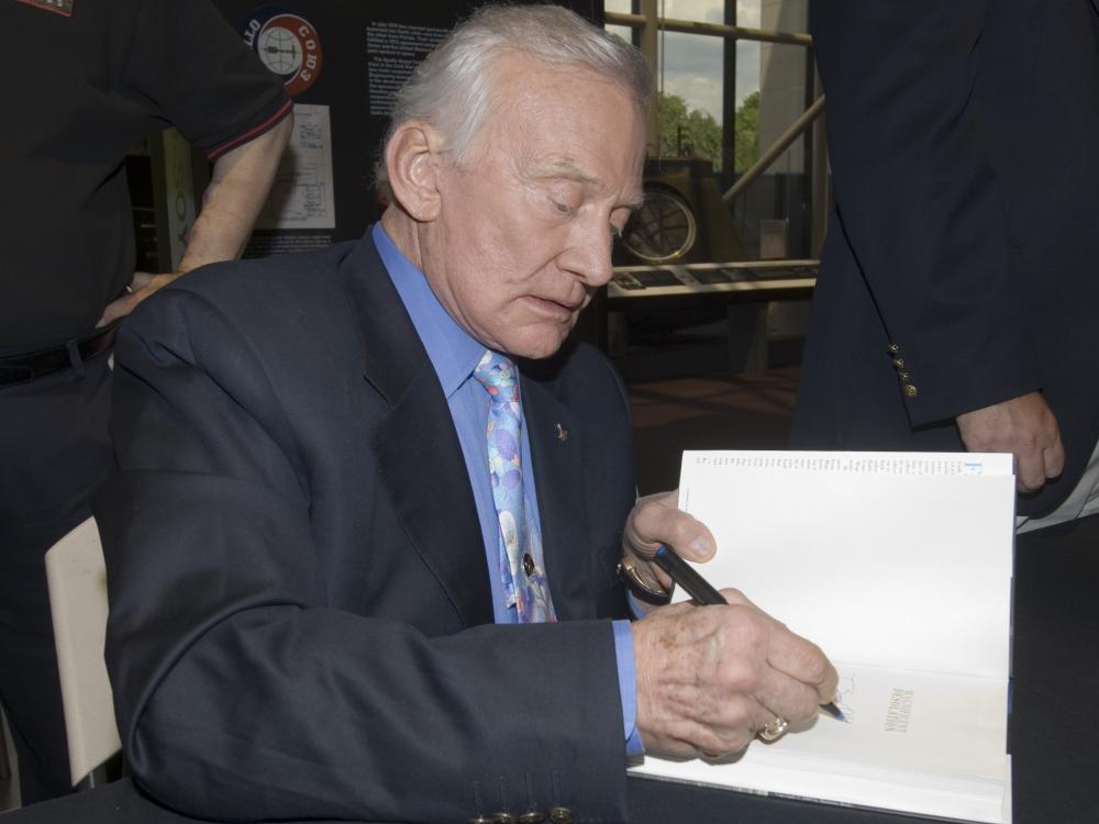 Buzz Aldrin signs book for a fan