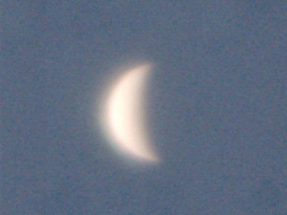 View of Venus as a waning crescent during daytime hours.