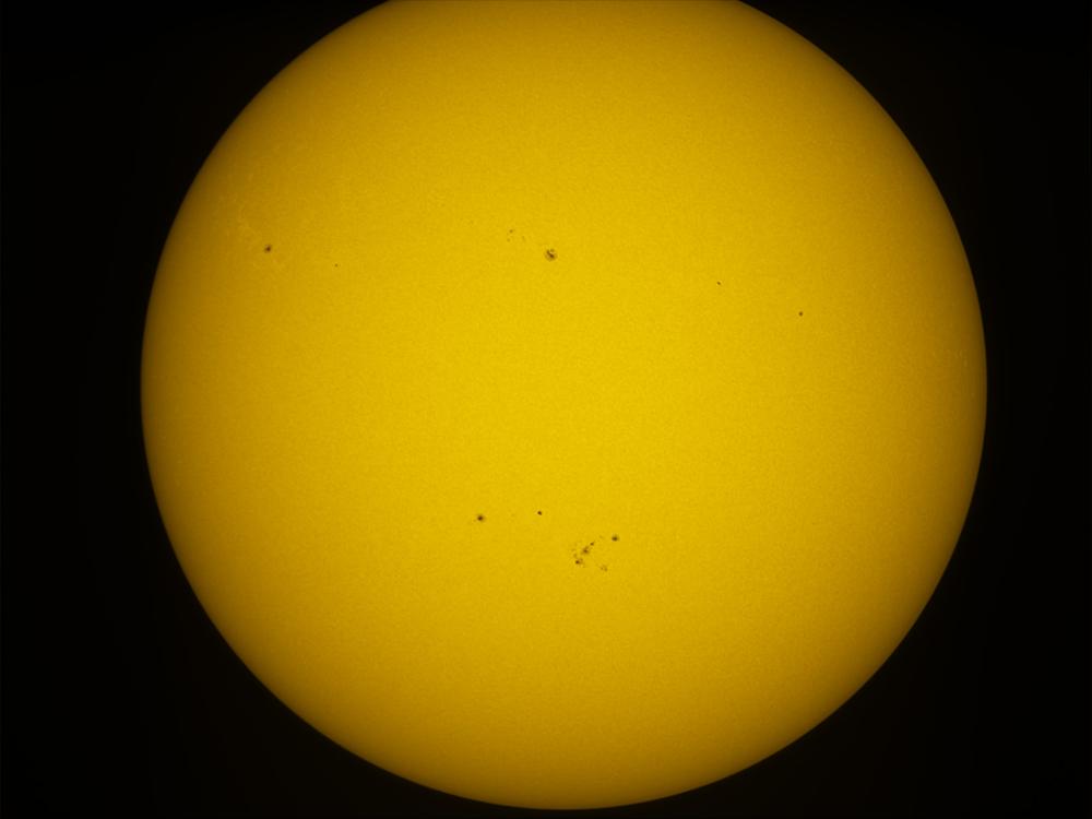 Disk view of the Sun with a solar flare visible in the bottom right quadrant of the Sun's visible surface.