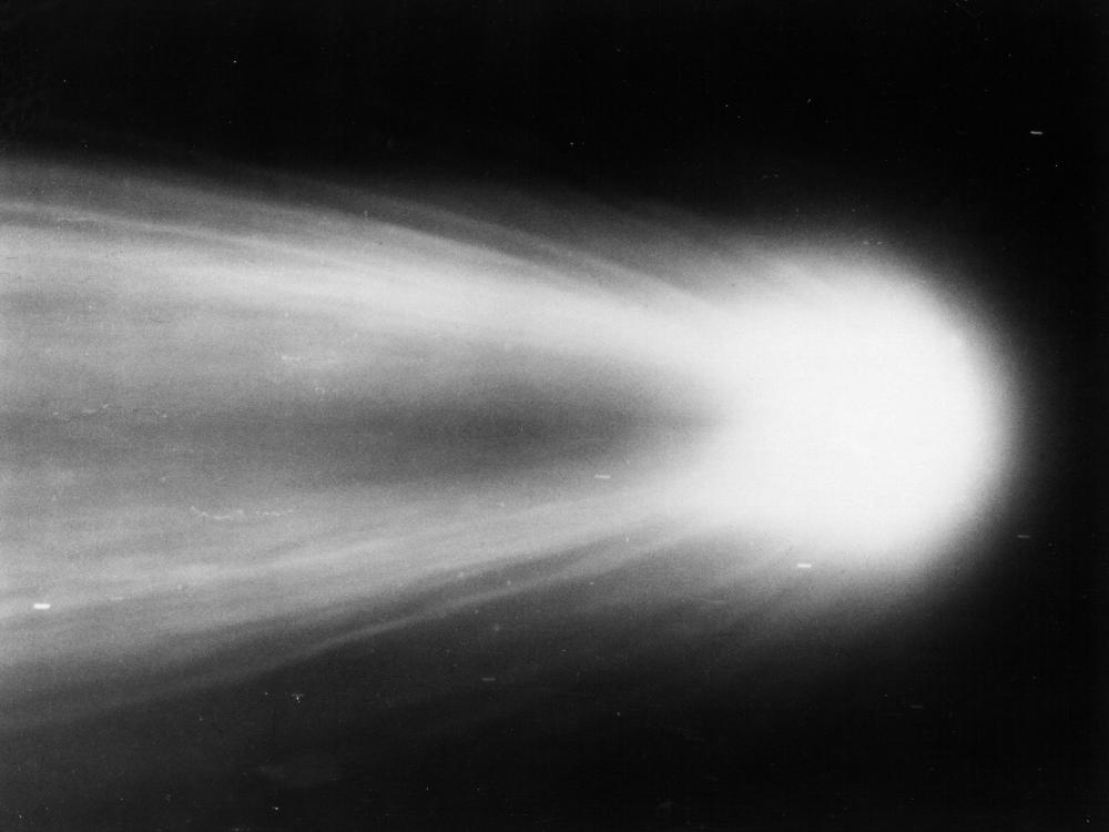 Close-up view of Halley's Comet as it leaves a meteor trail in the sky behind it.