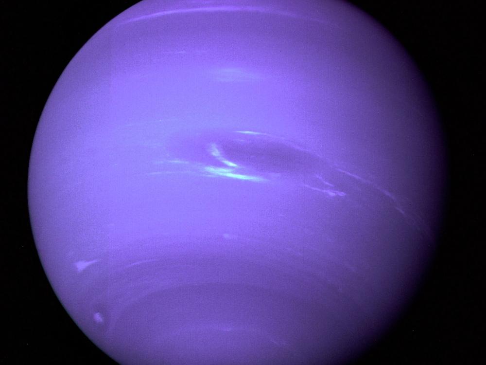 Full disk view of Neptune, a blue gas planet, with some lighter blue clouds visible.